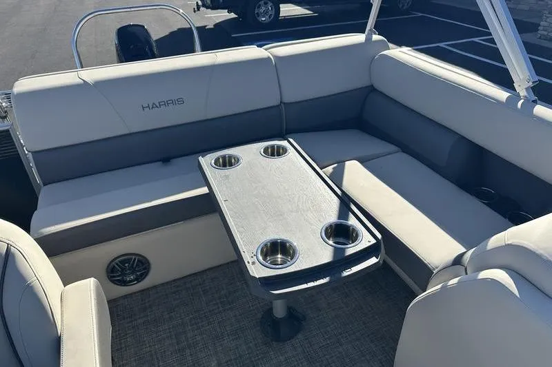 Slide: The Image of 2023 Harris Cruiser 210 CS boat interior with cushioned seating and table with cup holders. - 14
