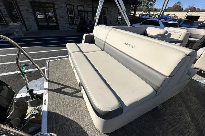 Slide: The Image of 2023 Harris Cruiser 210 CS pontoon boat with beige seating, parked outdoors. - 21
