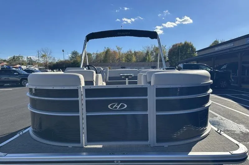 Slide: The Image of 2023 Harris Cruiser 210 CS pontoon boat in a parking lot under clear blue sky. - 5