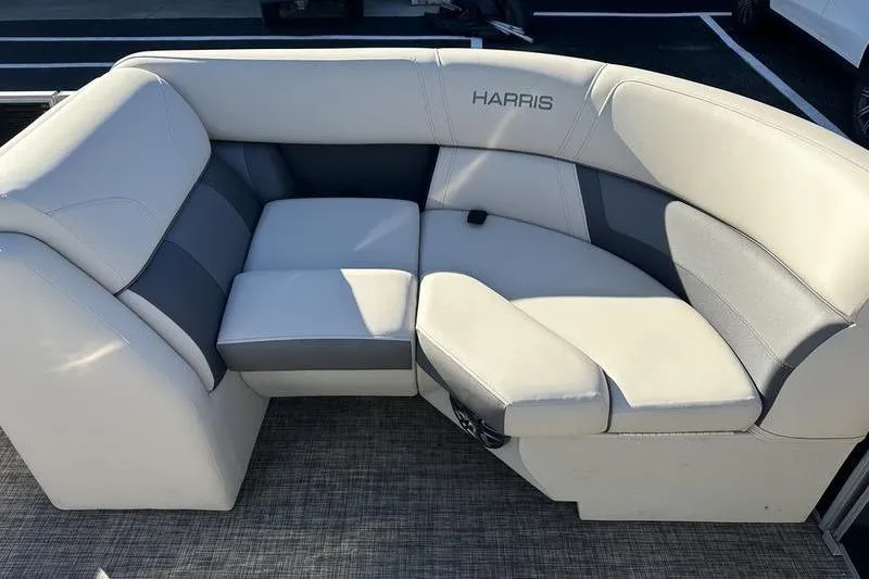 Slide: The Image of 2023 Harris Cruiser 210 CS boat seating, featuring plush, light gray upholstery with "Harris" branding. - 7