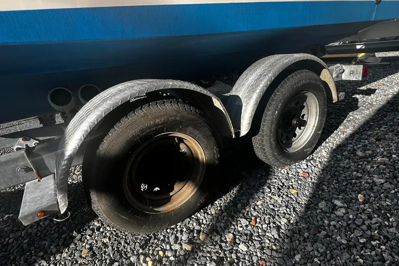 Slide: The Image of Trailer wheels of a 2013 Grady-White Freedom 205 boat on gravel surface. - 10