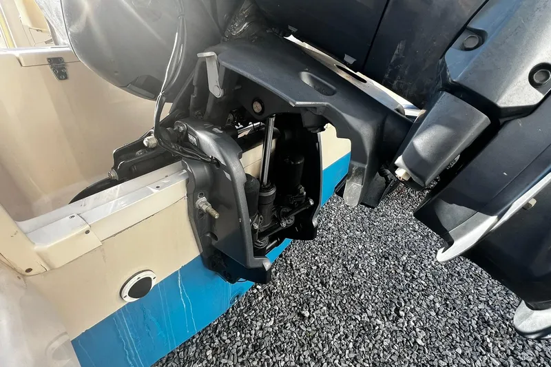 Slide: The Image of 2013 Grady-White Freedom 205 boat engine detail on gravel surface. - 15