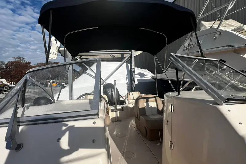 Slide: The Image of 2013 Grady-White Freedom 205 boat with canopy and seating, docked outdoors. - 22