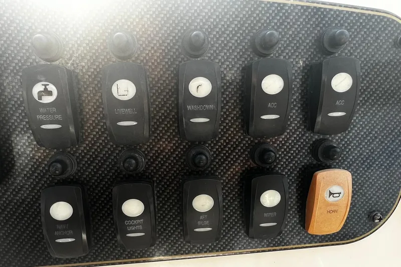 Slide: The Image of Control panel of a 2013 Grady-White Freedom 205 boat with various switches. - 28