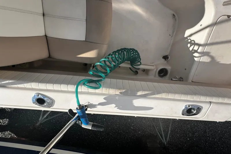Slide: The Image of 2013 Grady-White Freedom 205 boat interior with coiled green hose and seating. - 38