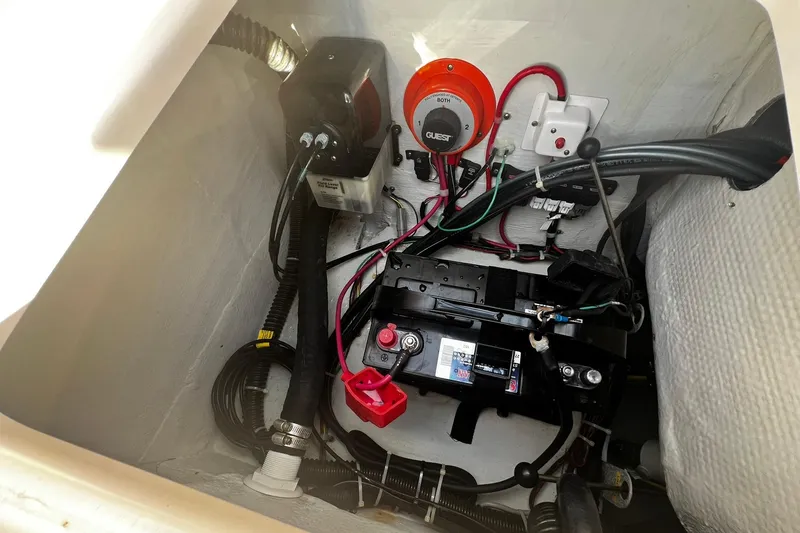 Slide: The Image of 2013 Grady-White Freedom 205 boat battery compartment with wiring and switches. - 43