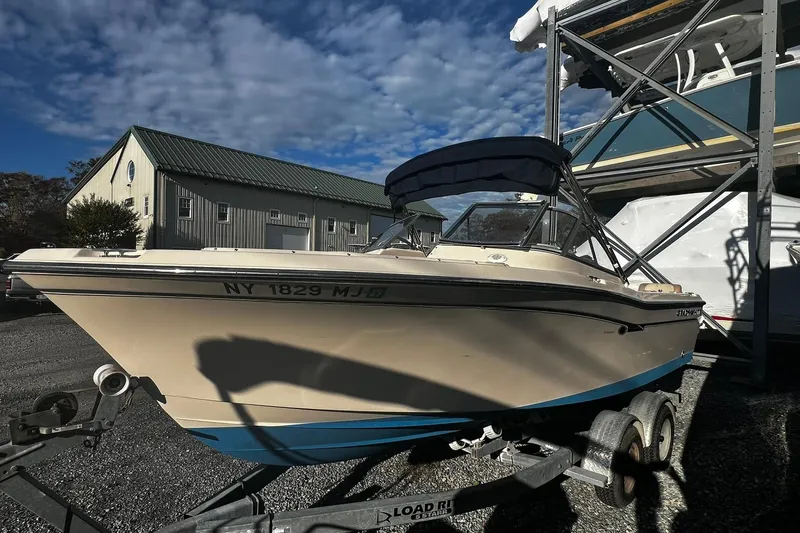 Slide: The Image of 2013 Grady-White Freedom 205 boat on trailer, parked outdoors under a clear sky. - 7