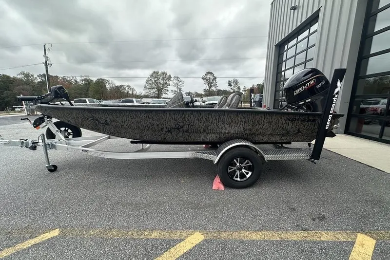 The Image of 2026 SeaArk ProCat 240 boat on trailer, parked outside a building under cloudy skies. - 2