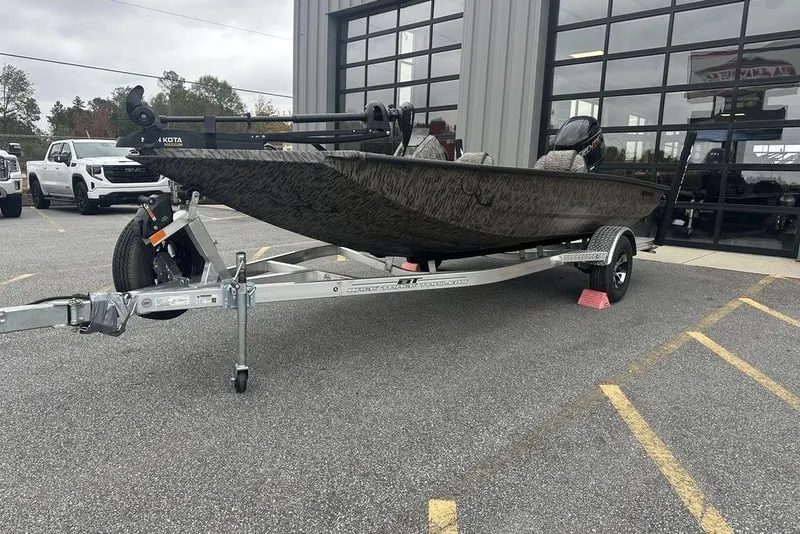 Slide: The Image of 2026 SeaArk ProCat 240 boat on trailer, parked outside a building. - 3