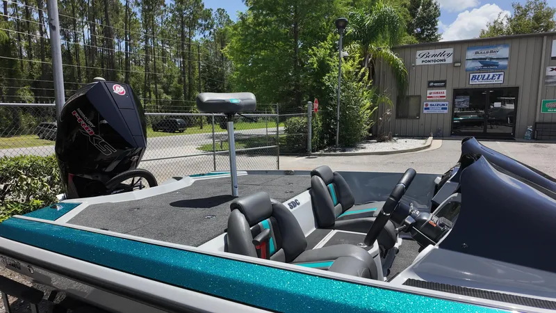 Slide: The Image of 2025 Bullet 21SDC boat with seating, motor, and dealership in background. - 10