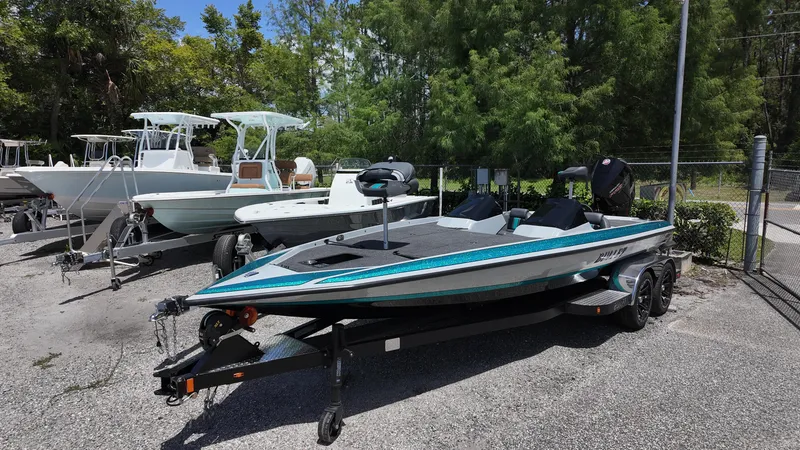 Slide: The Image of 2025 Bullet 21SDC boat on trailer, parked outdoors with trees in background. - 3