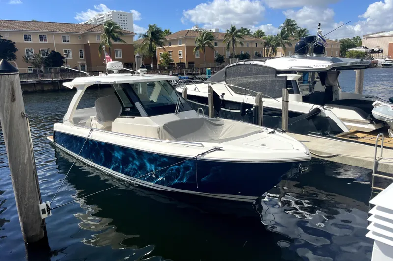 The Image of 2019 Tiara Sport 34 LS boat docked in a marina under a sunny sky. - 0