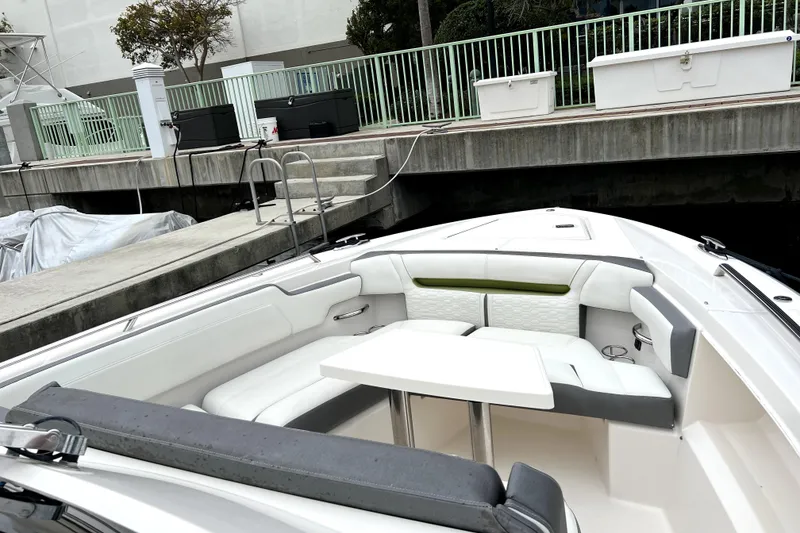 Slide: The Image of 2019 Tiara Sport 34 LS boat with white seating and table, docked at marina. - 11