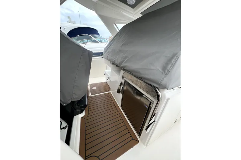 Slide: The Image of 2019 Tiara Sport 34 LS boat interior with covered seating and wooden flooring. - 12