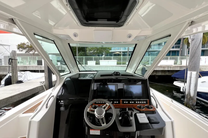 Slide: The Image of 2019 Tiara Sport 34 LS boat cockpit with modern navigation controls and steering wheel. - 14