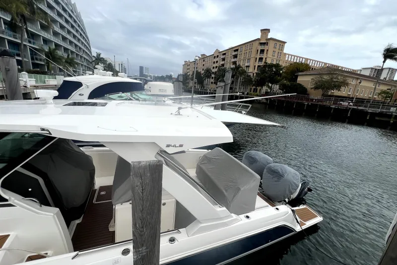 Slide: The Image of 2019 Tiara Sport 34 LS yacht docked near modern waterfront buildings. - 2
