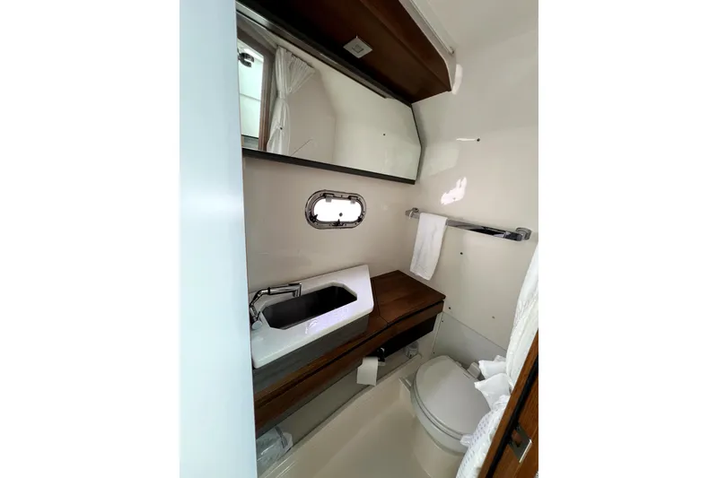 Slide: The Image of 2019 Tiara Sport 34 LS boat bathroom with sink, mirror, and toilet. - 23