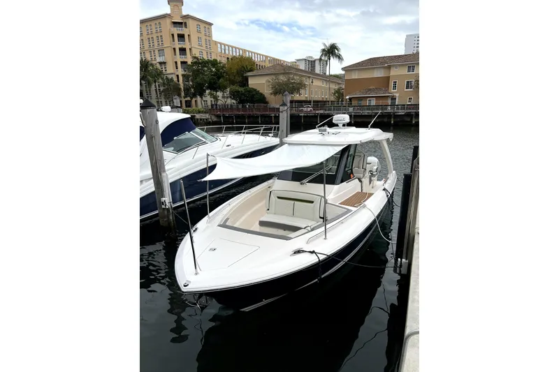 Slide: The Image of 2019 Tiara Sport 34 LS boat docked in a marina, featuring sleek design and sunshade. - 5