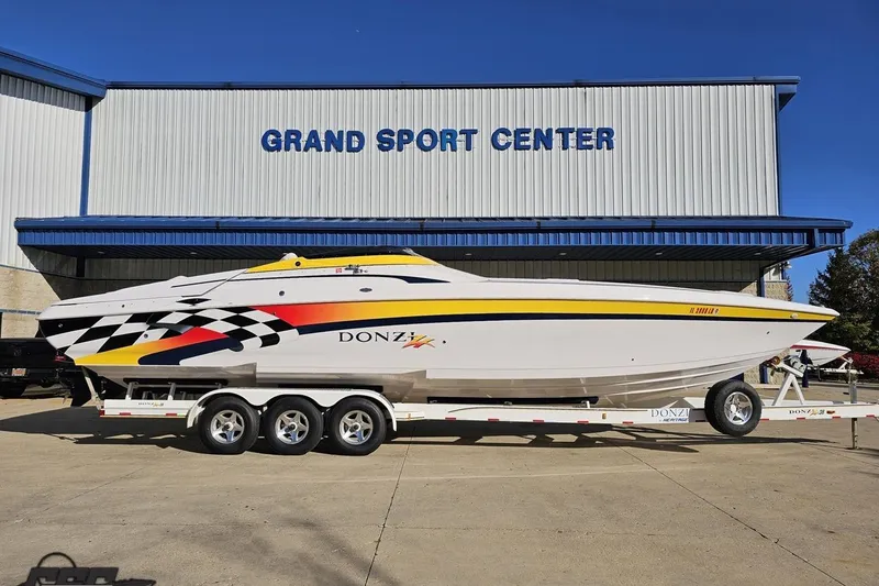 The Image of 2003 Donzi 38 ZX boat on trailer at Grand Sport Center, featuring vibrant racing graphics. - 1