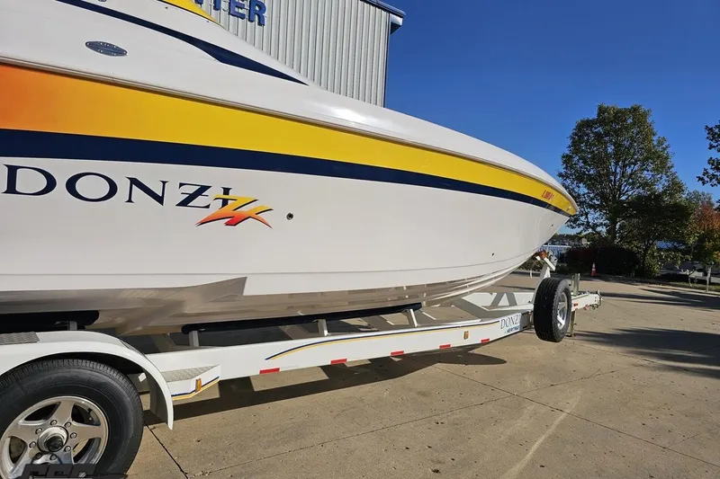 Slide: The Image of 2003 Donzi 38 ZX boat on trailer, vibrant yellow and white design, sunny day. - 12