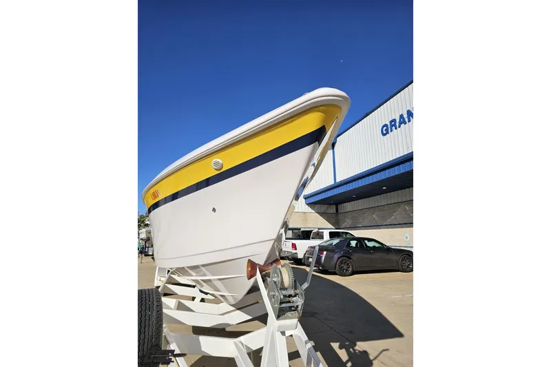 Slide: The Image of 2003 Donzi 38 ZX boat on trailer, yellow and white hull, parked outside a building. - 15
