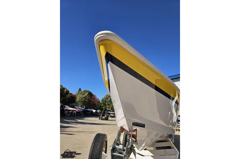 Slide: The Image of 2003 Donzi 38 ZX boat with yellow and black accents on a trailer under clear blue sky. - 16