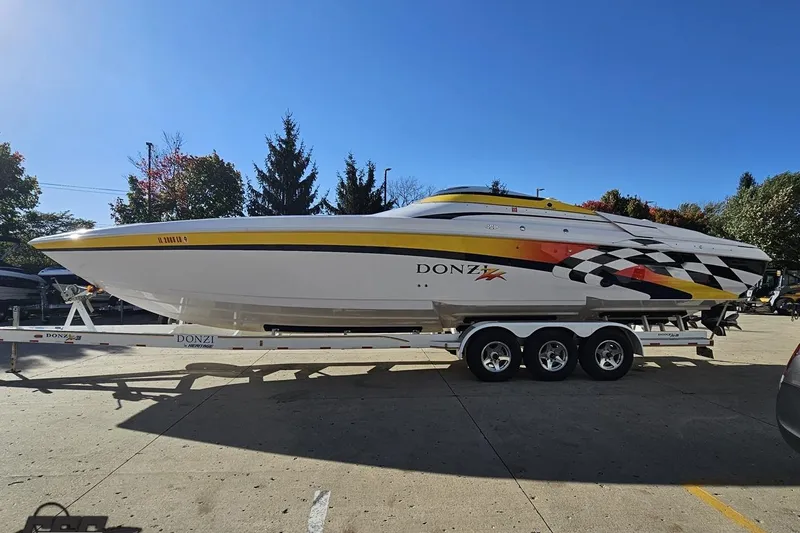 Slide: The Image of 2003 Donzi 38 ZX speedboat on trailer, vibrant graphics, parked outdoors. - 20