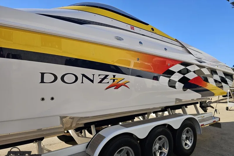 Slide: The Image of 2003 Donzi 38 ZX speedboat with vibrant racing graphics on a trailer. - 21