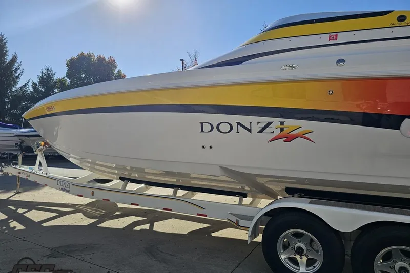 Slide: The Image of 2003 Donzi 38 ZX speedboat on trailer, vibrant yellow and orange accents. - 23