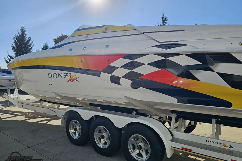 Slide: The Image of 2003 Donzi 38 ZX powerboat with vibrant racing graphics on a trailer. - 24