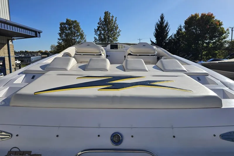Slide: The Image of 2003 Donzi 38 ZX boat with sleek design and cushioned seating, docked outdoors. - 30