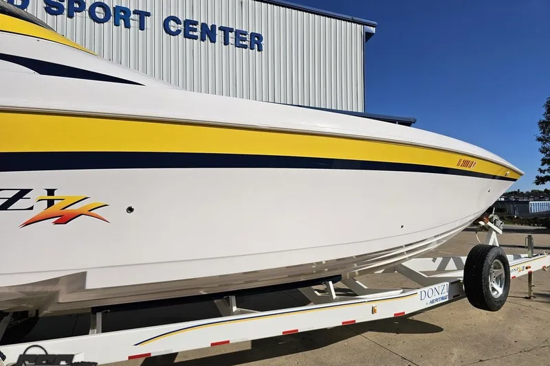 Slide: The Image of 2003 Donzi 38 ZX boat with yellow stripe on trailer at sport center. - 4