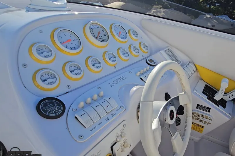Slide: The Image of 2003 Donzi 38 ZX boat dashboard with gauges, steering wheel, and controls. - 51