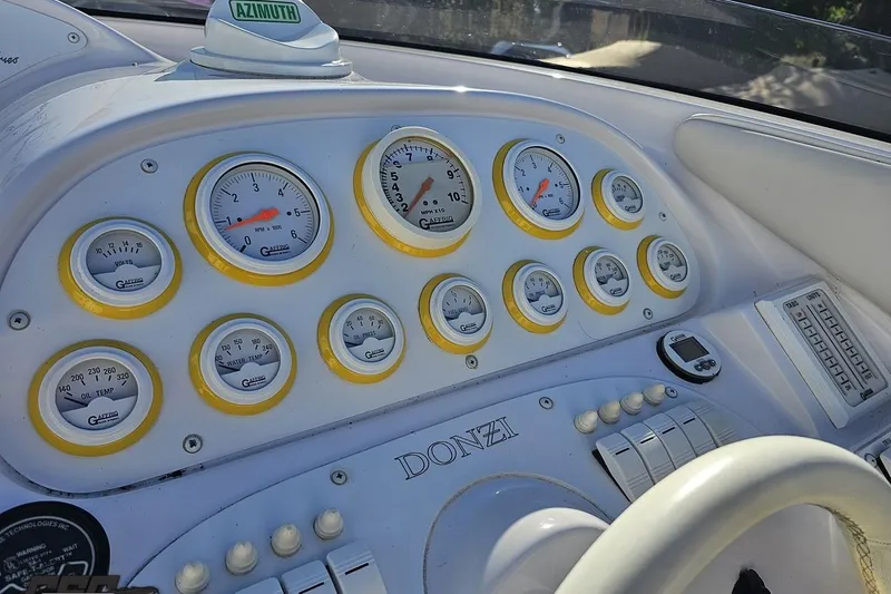 Slide: The Image of Dashboard of a 2003 Donzi 38 ZX boat with multiple gauges and controls. - 53