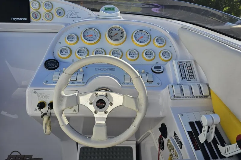 Slide: The Image of 2003 Donzi 38 ZX boat dashboard with steering wheel and gauges. - 54