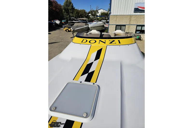 Slide: The Image of 2003 Donzi 38 ZX boat with yellow racing stripe, parked outdoors. - 60
