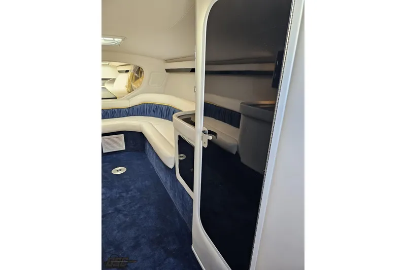 Slide: The Image of Interior of 2003 Donzi 38 ZX boat, featuring blue carpet and white seating. - 66