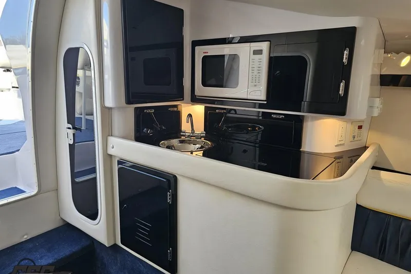 Slide: The Image of 2003 Donzi 38 ZX boat interior with kitchenette, featuring microwave and sink. - 68
