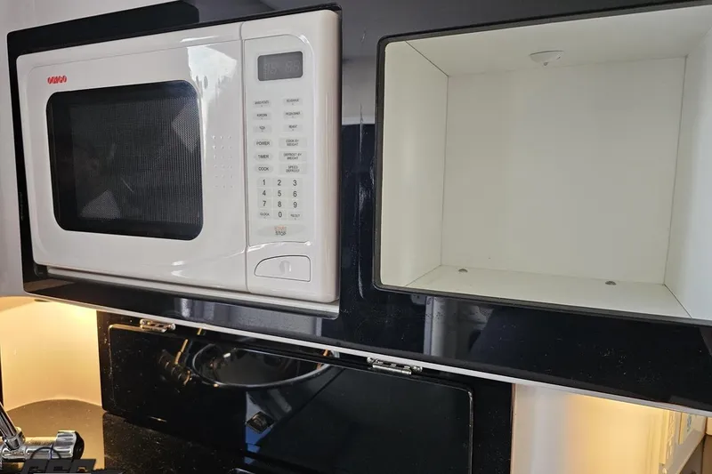 Slide: The Image of 2003 Donzi 38 ZX interior with microwave and storage compartment. - 73