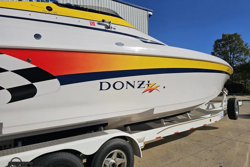 Slide: The Image of 2003 Donzi 38 ZX boat with vibrant graphics on a trailer, sunny day. - 8
