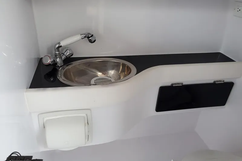 Slide: The Image of 2003 Donzi 38 ZX boat interior sink with faucet and storage compartment. - 87