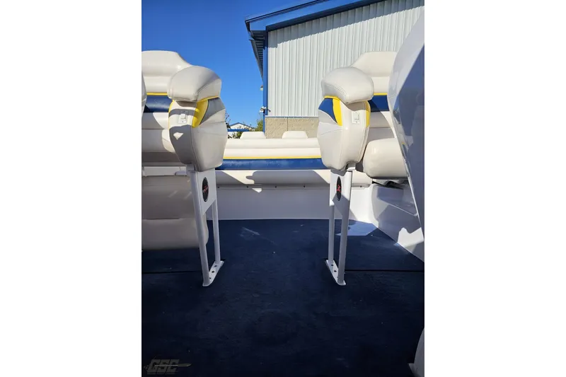 Slide: The Image of 2003 Donzi 38 ZX boat interior with white and yellow seating, blue carpet, and sunny backdrop. - 89