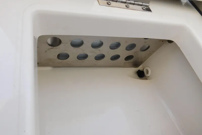 Slide: The Image of 2024 Pursuit DC 326 Dual Console storage compartment with metal ventilation panel. - 17