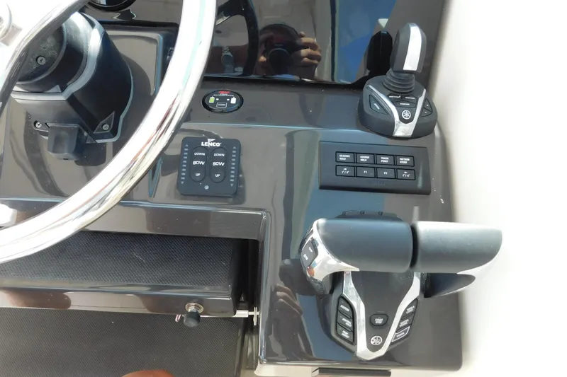 Slide: The Image of 2024 Pursuit DC 326 Dual Console boat dashboard with steering wheel and controls. - 36