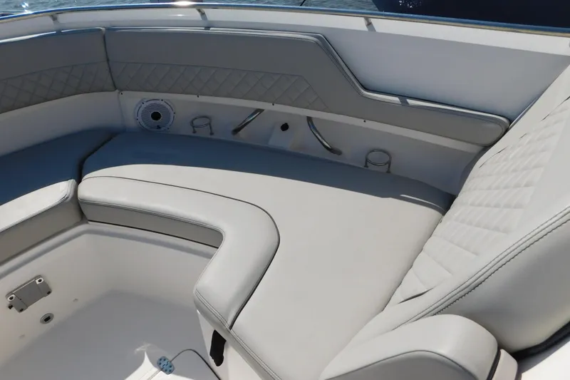 Slide: The Image of 2024 Pursuit DC 326 Dual Console boat interior with cushioned seating and cup holders. - 50