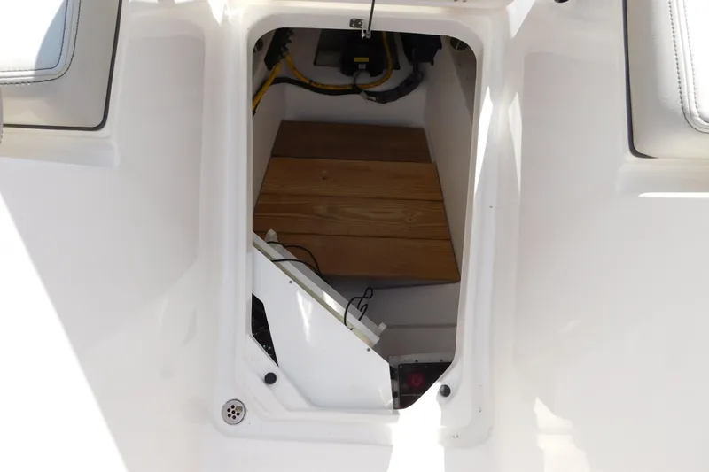 Slide: The Image of 2024 Pursuit DC 326 Dual Console interior storage compartment with wooden flooring. - 60