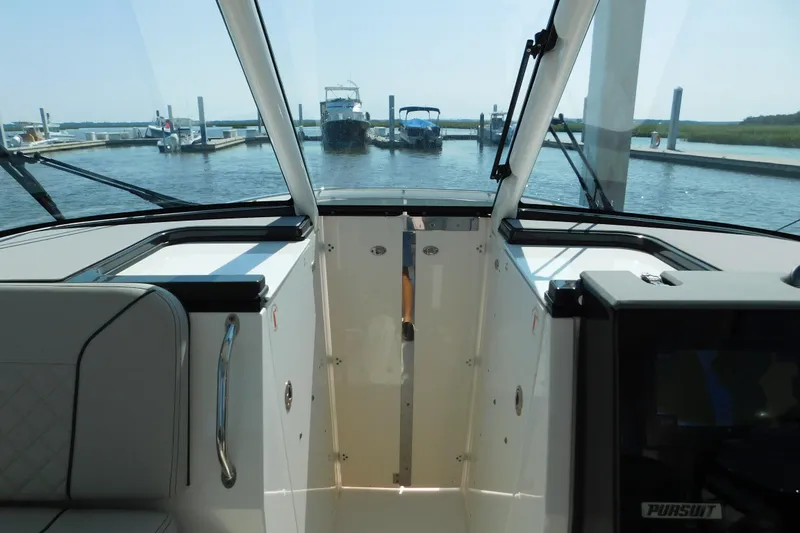 Slide: The Image of 2024 Pursuit DC 326 Dual Console interior view at marina dock. - 63