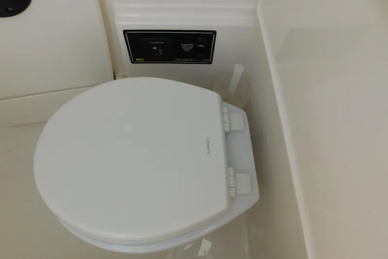 Slide: The Image of 2024 Pursuit DC 326 Dual Console boat toilet with control panel. - 66
