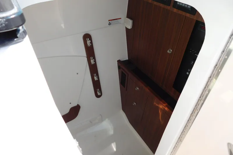 Slide: The Image of 2024 Pursuit DC 326 Dual Console interior with wood paneling and storage cabinets. - 67