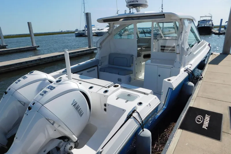 Slide: The Image of 2024 Pursuit DC 326 Dual Console boat docked with twin Yamaha engines. - 7